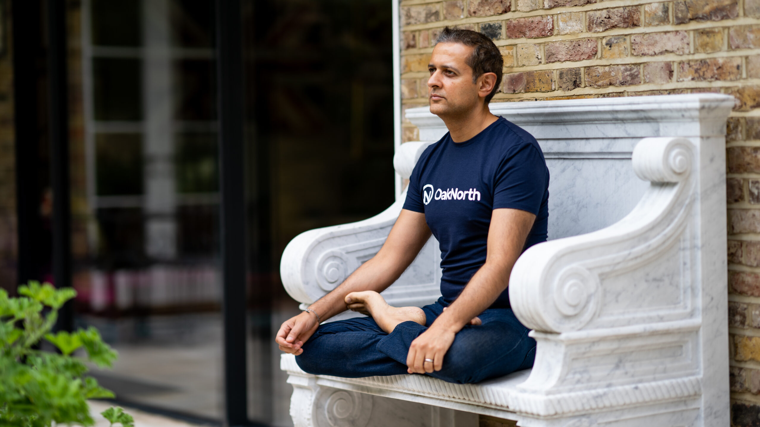 Rishi Khosla sitting cross legged in the garden