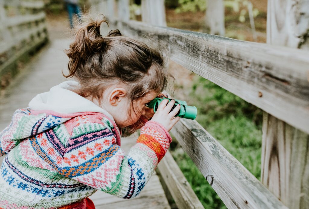 Little girl looking through binoculars