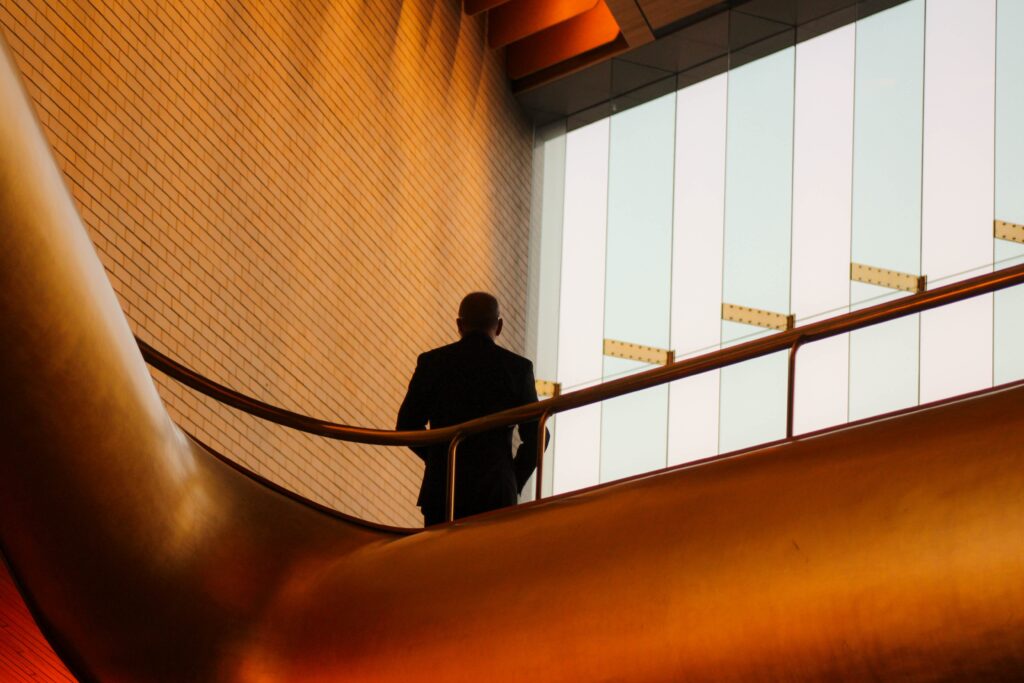 Man stood on curved stairwell with light shining on him